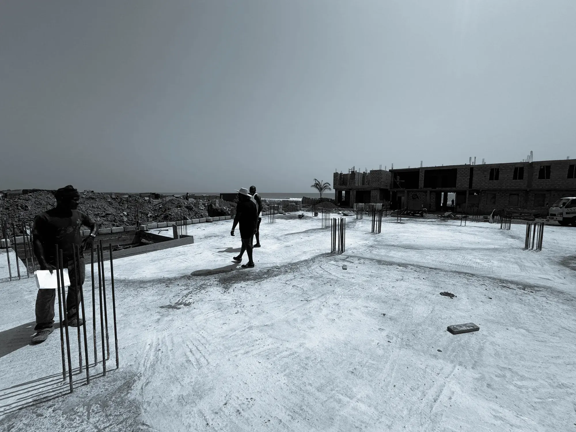 Workers continuing slab construction at Oura by Bamboo beside the coast